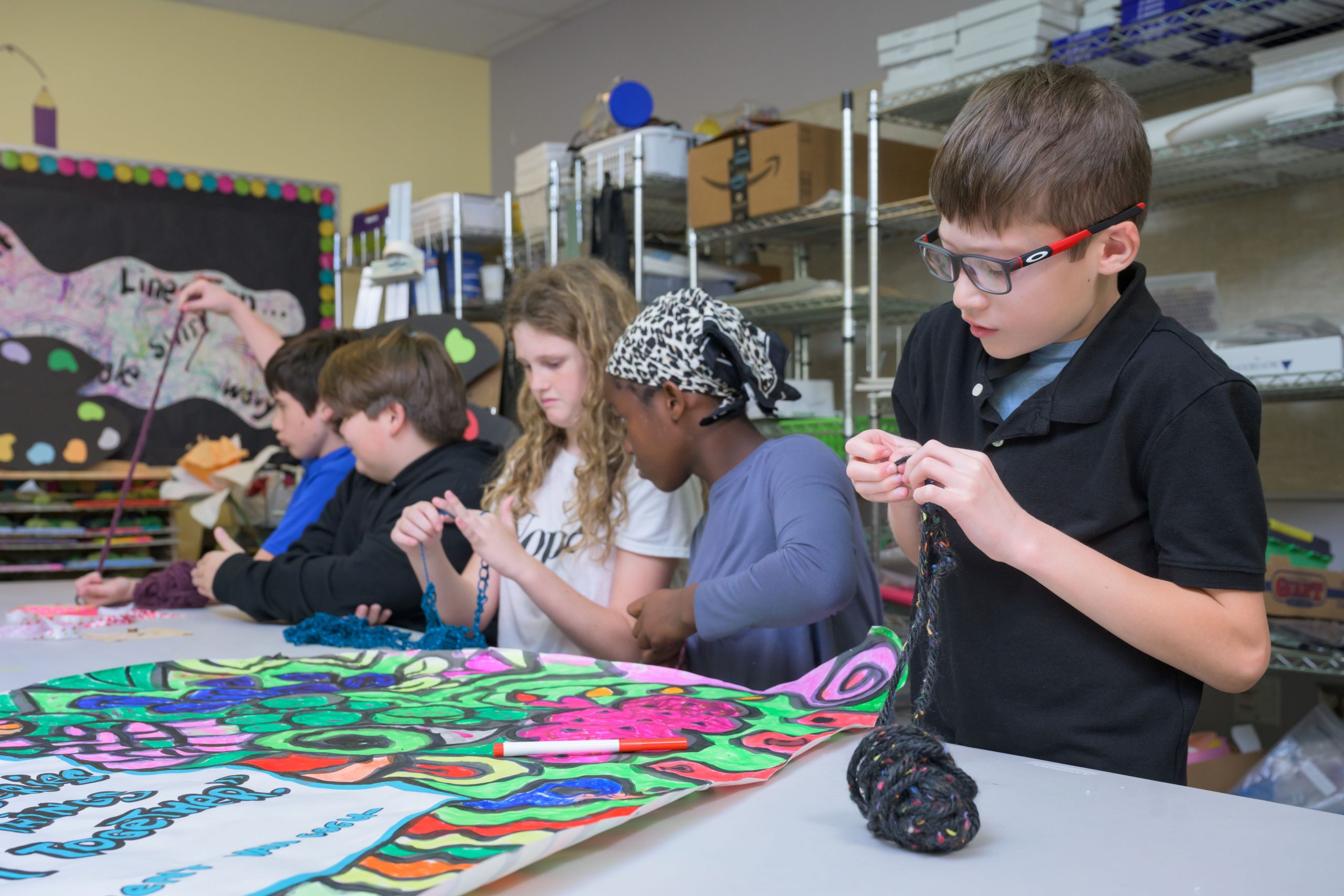 TCS students working on art projects like finger knitting and drawing